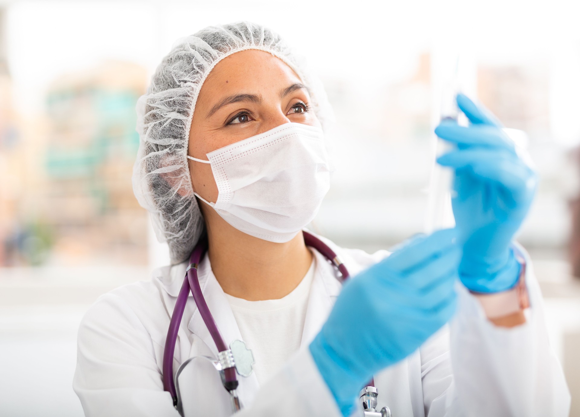 Trabajadora de la salud prepara una jeringa inyectable en la sala de tratamiento
